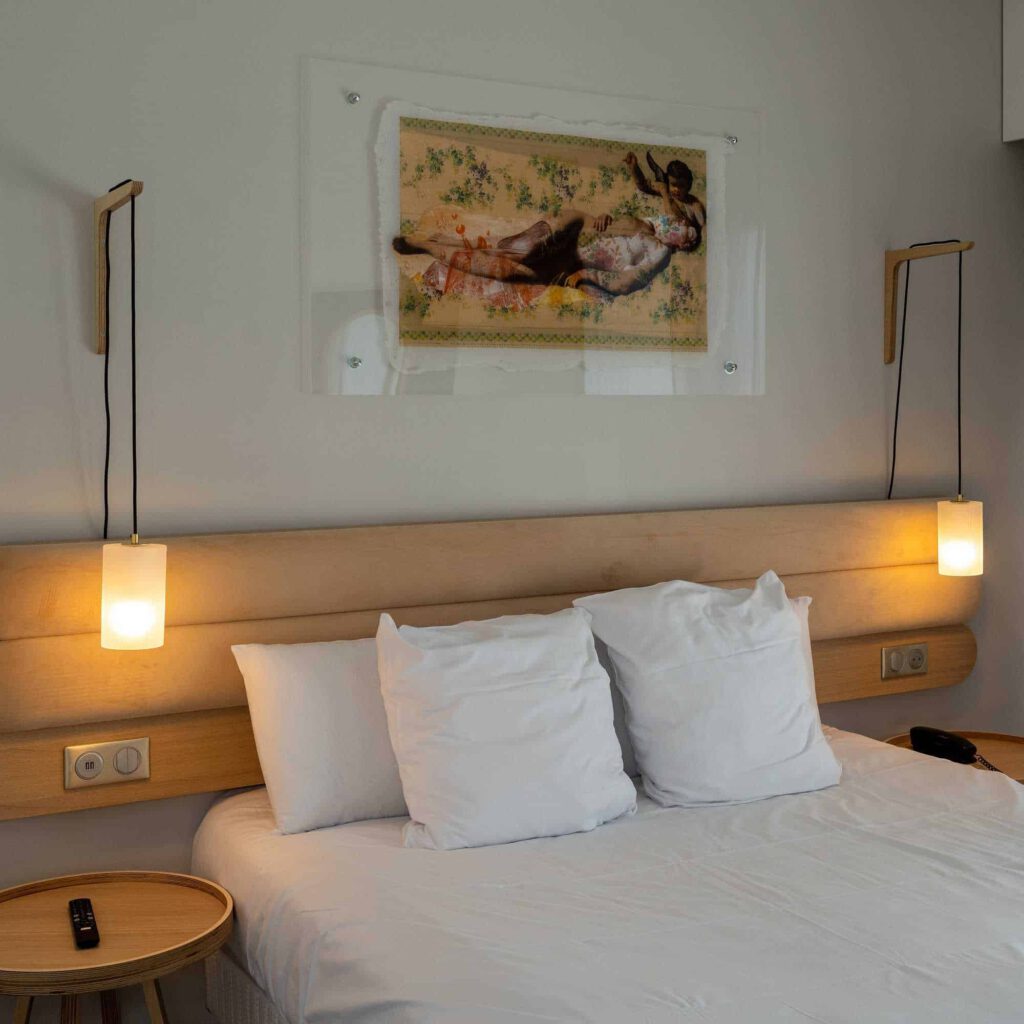 Chambre moderne avec lit confortable, éclairage design et œuvres d'art.