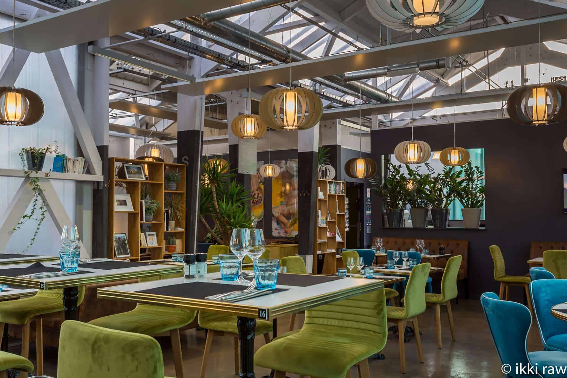 Interior moderno del restaurante Hôtel Libéra, con mesas elegantes y decoración industrial-chic.