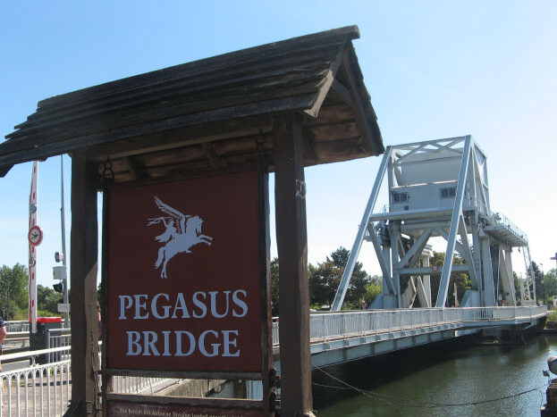 Panneau d'entrée du Pont Pegasus, un pont emblématique situé à Caen, en Normandie, surplombant un canal.