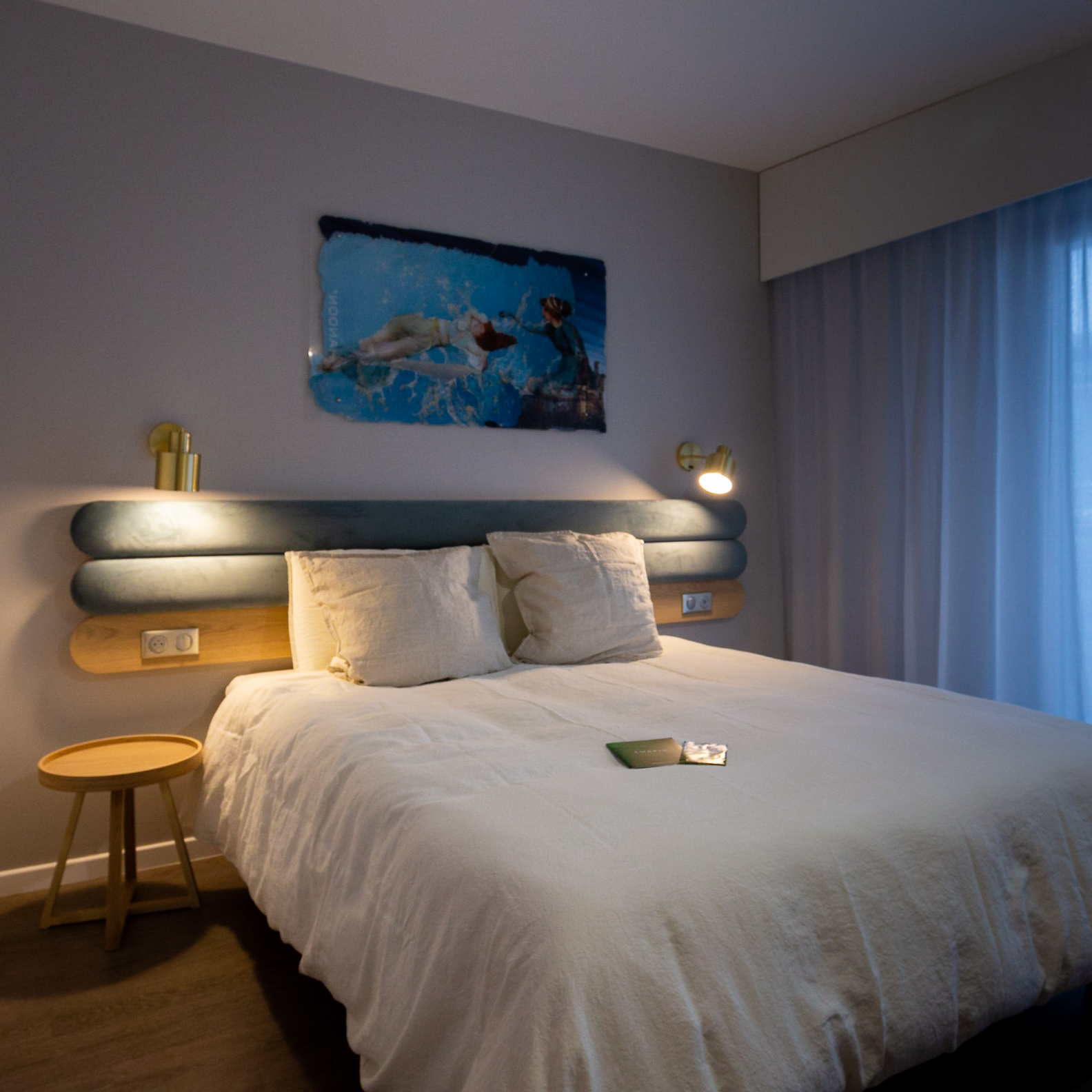Habitación exclusiva y moderna del Hôtel Libéra, con cama espaciosa, iluminación tenue y decoración de paredes.